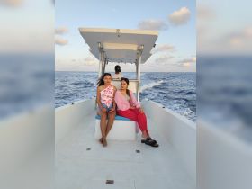 Two friends enjoy a scenic boat ride on the ocean, capturing the essence of adventure and camaraderie on the water.