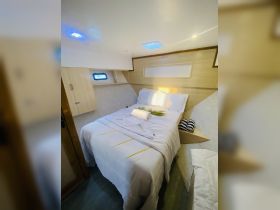 Cozy cabin interior featuring a comfortable bed and stylish decor, perfect for relaxing on a boat getaway.