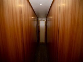 A well-finished wooden hallway inside a boat, showcasing the elegant interior design typical of marine cabins.