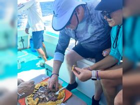 Guests enjoy a delicious seafood platter onboard, showcasing the perfect culinary experience while out at sea.