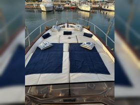 A cozy lounge area on a boat featuring plush cushions and towels, perfect for relaxing on the water.