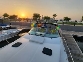 A festive boat adorned with colorful balloons at sunset, perfect for celebrations and gatherings on the water.