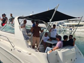 A lively group enjoys their time aboard a Sundancer boat, celebrating with drinks and camaraderie — perfect for a fun day on the water.