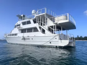 A stunning view of a spacious yacht docked in clear waters, showcasing its elegant design and structure, perfect for luxury charters and private events.