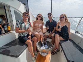 A cheerful group enjoys cocktails aboard a yacht, perfect for celebrations and memorable outings on the water.