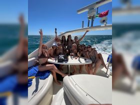 A lively group of friends celebrates on a yacht, enjoying drinks and sunshine — perfect for bachelorette parties or fun outings on the water.