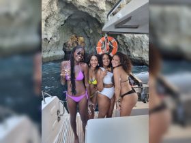 A joyful group of friends poses together on a boat, celebrating with drinks in hand — perfect for memorable summer outings and fun adventures on the water.