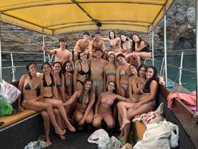 A lively group of friends enjoys a fun day on the boat, showcasing the perfect atmosphere for summer parties and swimming adventures.