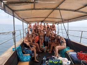 A lively group of friends enjoys a fun day aboard a boat, capturing the essence of celebration and camaraderie on the water.