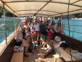 A lively group of friends enjoys a fun day on a boat, celebrating and making memories under the sun — perfect for summer outings and party adventures.