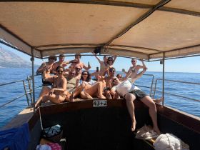 A lively group of friends enjoys a sunny day on the boat, celebrating and having fun on the water — perfect for summer outings and memorable adventures.