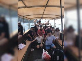 A lively group of friends enjoys a fun day on the boat, capturing memories and celebrating together under the sun.