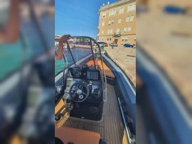 An interior view of a boat's helm and seating area, showcasing the controls and comfortable seating, perfect for navigating the waters.