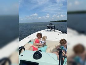 A fun moment on a boat with friends, featuring a surprised expression and a dog enjoying the ride — perfect for memorable summer outings.