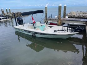 A center console boat docked at a marina, showcasing its sleek design and readiness for fishing or leisure activities on the water.