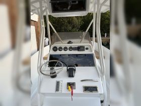 A detailed view of the helm and console area inside a boat, showcasing the steering wheel and control panel — ideal for navigating the waters.