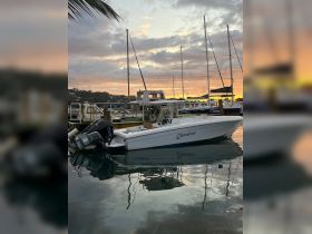 A serene view of the 'Elevation' boat docked at sunset, reflecting the vibrant colors of the sky on the calm waters.