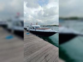 A sleek yacht docked at the marina, showcasing its elegant design against a cloudy sky — perfect for luxury boating experiences.