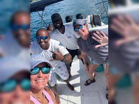 A cheerful group of friends poses for a selfie on a boat, capturing the joy of their day on the water — perfect for memorable outings and adventures.
