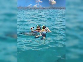 Two excited snorkelers enjoy a vibrant underwater adventure in crystal-clear waters, capturing the joy of marine exploration.