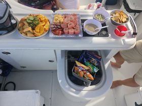 A vibrant spread of snacks and fruits laid out on a boat, perfect for enjoying a day on the water with friends or family.