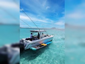 A group of people aboard a boat enjoying the clear turquoise waters, showcasing a perfect day for water activities and relaxation.