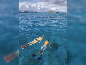 A couple enjoys snorkeling in crystal-clear waters, exploring the vibrant marine life and stunning underwater scenery — a perfect adventure for ocean lovers.