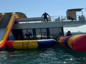 A vibrant inflatable slide and water toys are set up on a boat, perfect for fun-filled days on the water. Guests can enjoy thrilling water activities while soaking up the sun.