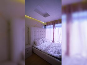 A cozy and modern cabin interior featuring a comfortable bed and soft lighting, perfect for relaxing on a boat getaway.