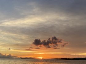 A breathtaking sunset over the coastline, showcasing vibrant colors reflecting on the water — a perfect backdrop for evening boat trips and romantic getaways.