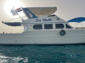 A side view of the 'Sea Master' yacht, showcasing its elegant design against a serene backdrop of turquoise waters.