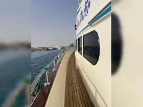 A side view of the 'Sea Master' yacht showcasing its elegant design and polished wooden deck, perfect for luxury cruising.