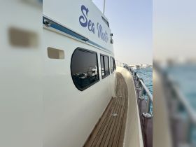 A close-up view of the 'Sea Master' boat's exterior, showcasing its sleek design and polished wooden deck, perfect for a day out on the water.