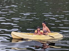 A mother and her child enjoy a fun kayaking adventure on calm waters, creating memorable family moments in nature.
