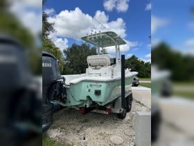 A clear view of a center console boat parked and ready for adventure, showcasing its sleek design against a bright blue sky.