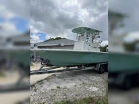 A pristine center console boat docked and ready for adventure, showcasing its sleek design and features under a cloudy sky.