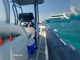 A view of the helm and seating area inside a boat, showcasing the console and storage, perfect for navigating the open waters.