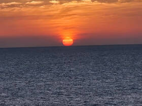A stunning sunset over the ocean, creating a picturesque backdrop perfect for evening boat cruises or romantic getaways on the water.