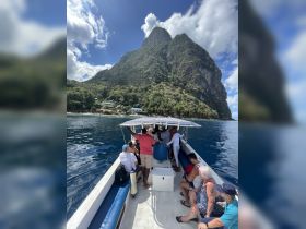 A lively group enjoys a boat ride with stunning mountain scenery in the background, capturing the essence of adventure on the water.