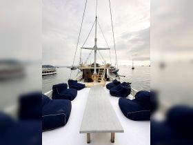 A cozy interior view of a boat featuring comfortable bean bag seating and a long table, perfect for relaxing and socializing while enjoying the serene waters.