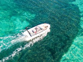 A boat navigates through stunning turquoise waters, showcasing an exciting day on the water with friends or family.