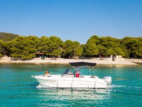 A scenic view of a boat cruising through clear turquoise waters, with lush greenery in the background — perfect for exploring coastal destinations.