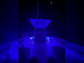 A captivating view of the boat's interior illuminated by blue lighting, showcasing the helm area in a serene nighttime setting.