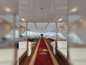 Interior view of a luxurious boat cabin featuring elegant seating and a helm, perfect for comfortable cruising experiences.