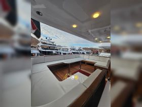 A spacious interior seating area on a yacht, featuring elegant furnishings and a stylish table, perfect for relaxation and socializing while on the water.