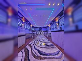 A stylish interior view of a boat's lounge area featuring modern lighting and elegant seating, perfect for relaxing and entertaining guests on the water.