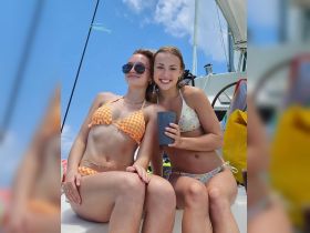 Two friends enjoy a sunny day on a boat, capturing the essence of summer fun and friendship on the water.