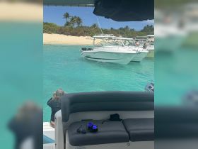 Guests enjoy a beautiful day on the water, with boats anchored near a sandy beach — perfect for snorkeling and relaxation in the sun.
