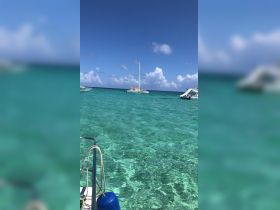 A serene view of a catamaran anchored in crystal-clear waters, perfect for exploring tropical destinations.