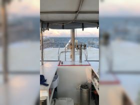 Inside view of the helm area on a boat, showcasing the controls and spacious layout, perfect for navigating the open waters.